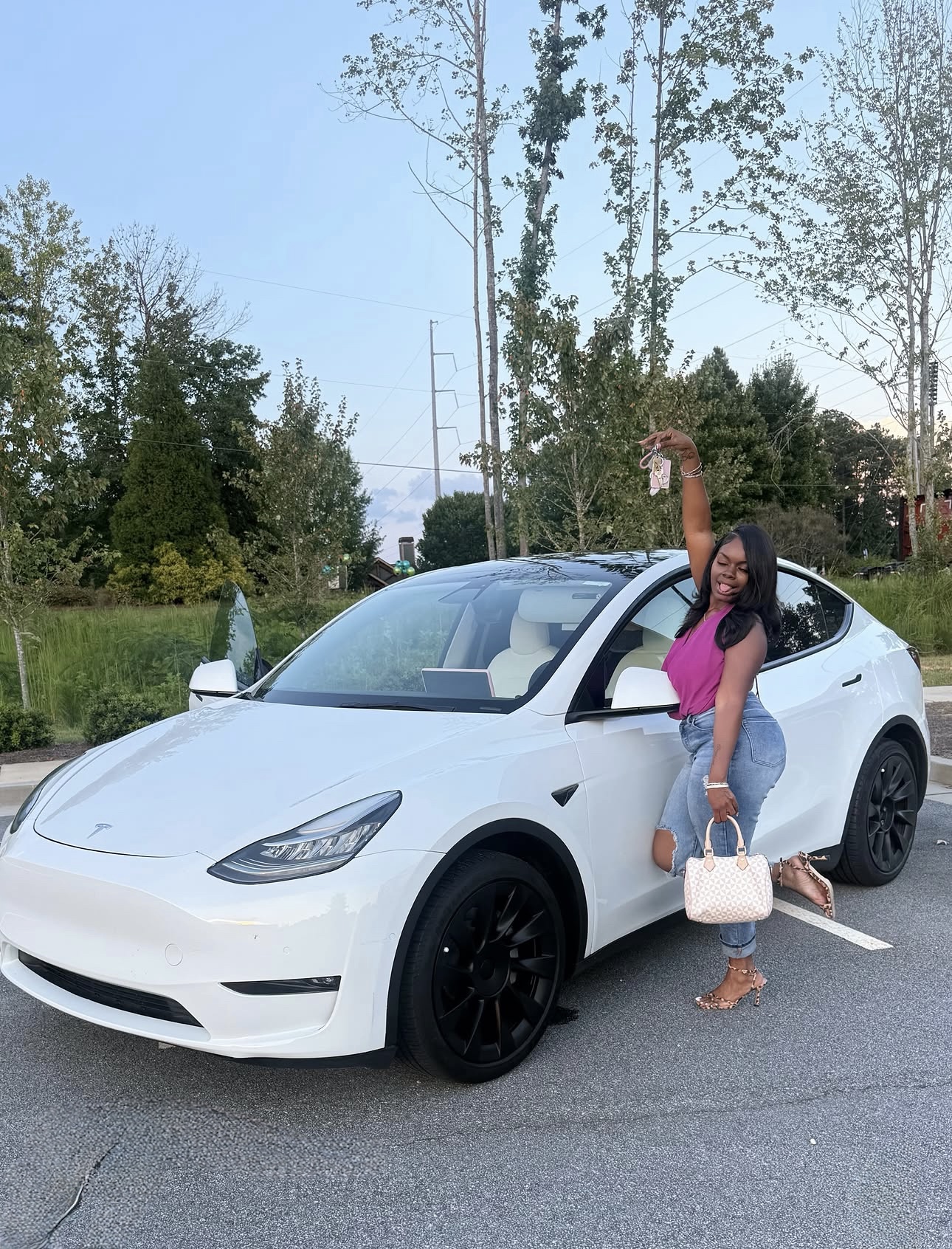 Customer holding her keys next to a white Tesla Model Y