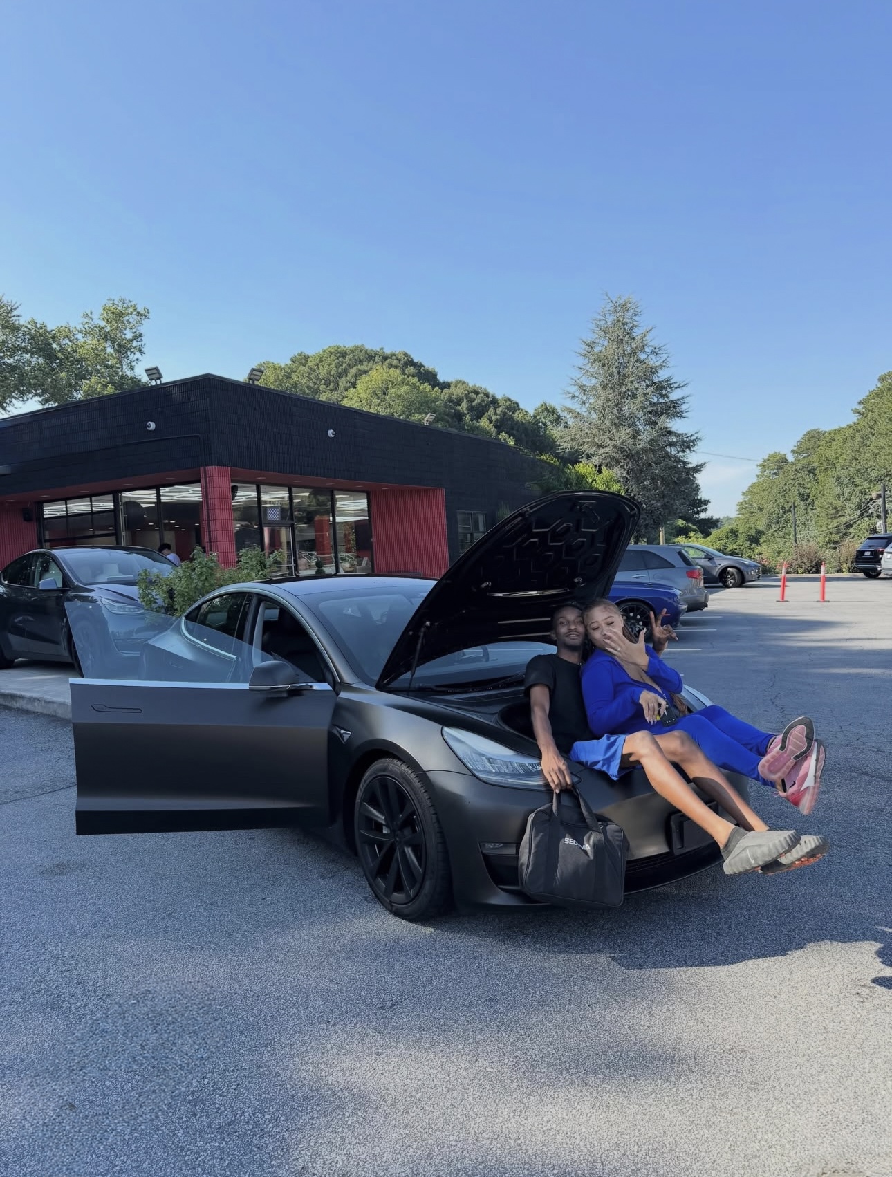 Happy Rich Autos customers with their new Tesla